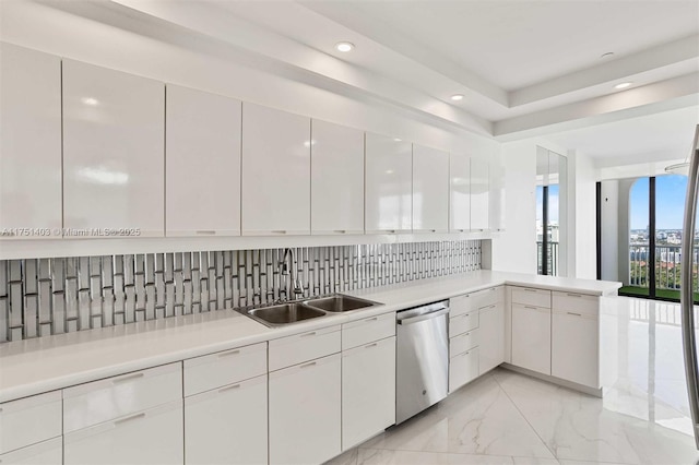 kitchen featuring light countertops, stainless steel dishwasher, a sink, and tasteful backsplash