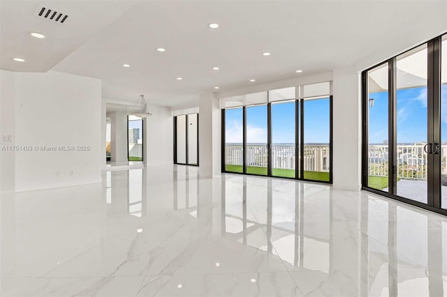 unfurnished room with expansive windows, visible vents, plenty of natural light, and recessed lighting