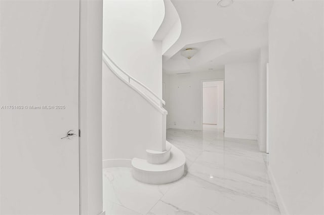 stairs with marble finish floor and baseboards