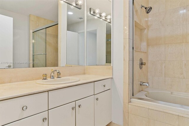 bathroom featuring tiled shower / bath combo and vanity