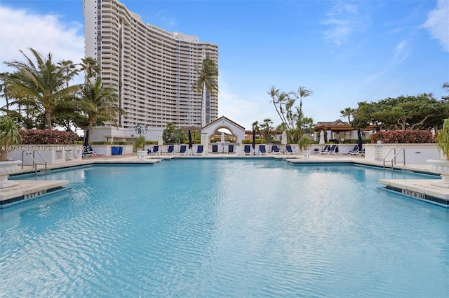 community pool with a patio area and fence