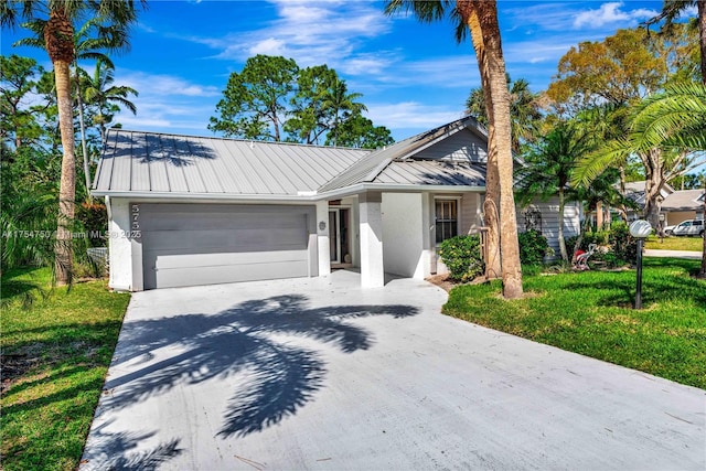 view of front of house featuring driveway, metal roof, and stucco siding