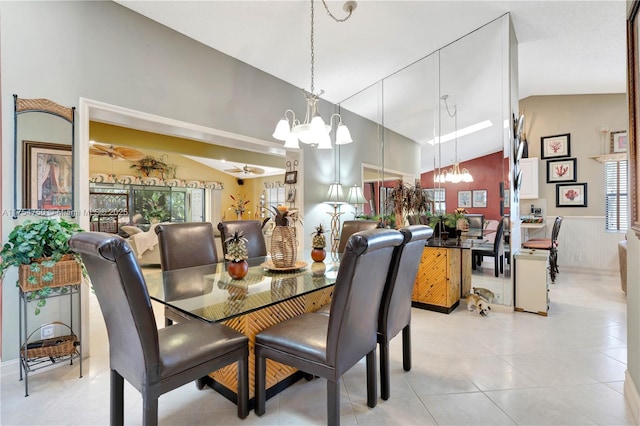 dining room featuring vaulted ceiling, ceiling fan with notable chandelier, and wainscoting