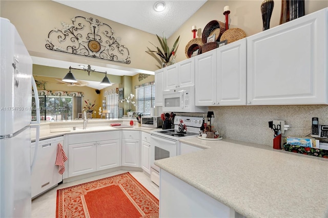kitchen with light countertops, white appliances, white cabinets, and a sink