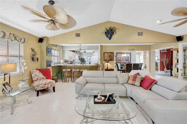 tiled living room with a ceiling fan, visible vents, and vaulted ceiling