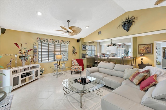 living room featuring lofted ceiling, plenty of natural light, visible vents, and light tile patterned flooring