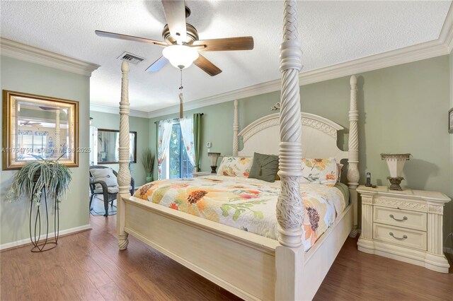 bedroom with crown molding, a textured ceiling, visible vents, and wood finished floors