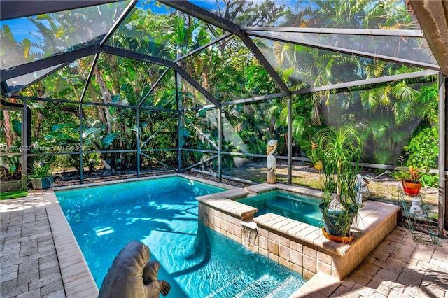 view of swimming pool featuring a pool with connected hot tub, glass enclosure, and a patio