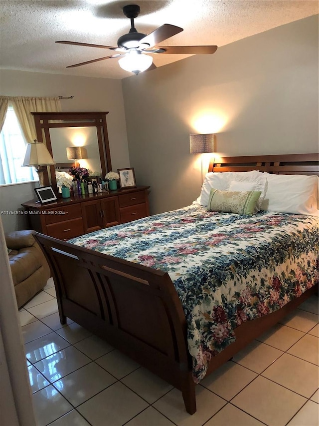 bedroom featuring a textured ceiling, ceiling fan, and light tile patterned floors