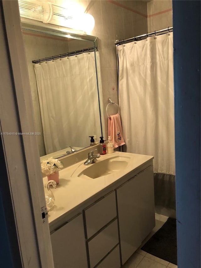 full bathroom featuring tile patterned flooring and vanity