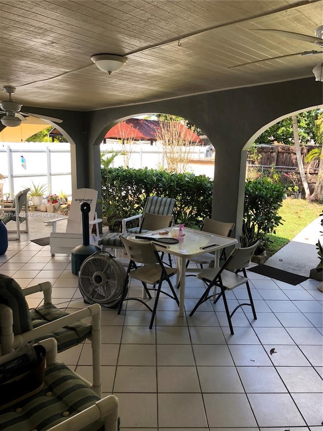 view of patio featuring ceiling fan, fence, and outdoor dining space