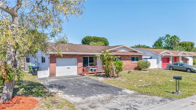 single story home featuring a garage, brick siding, driveway, and a front lawn