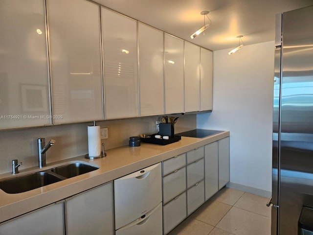 kitchen featuring high end fridge, white dishwasher, a sink, and white cabinets