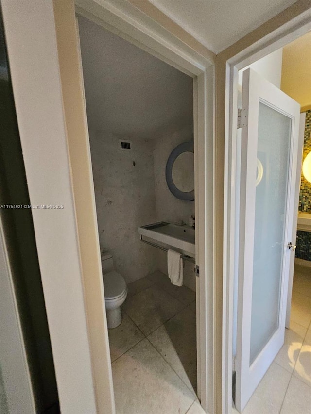 bathroom with visible vents, toilet, and tile patterned floors