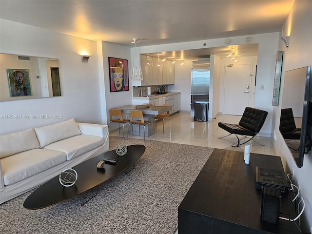 living area with light tile patterned floors, baseboards, and visible vents