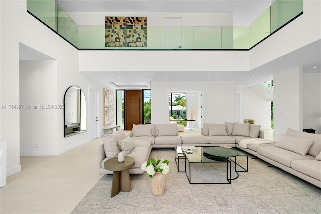 living room featuring a high ceiling, recessed lighting, and baseboards