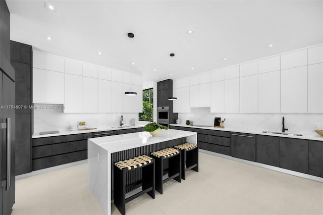 kitchen featuring light countertops, modern cabinets, and a sink