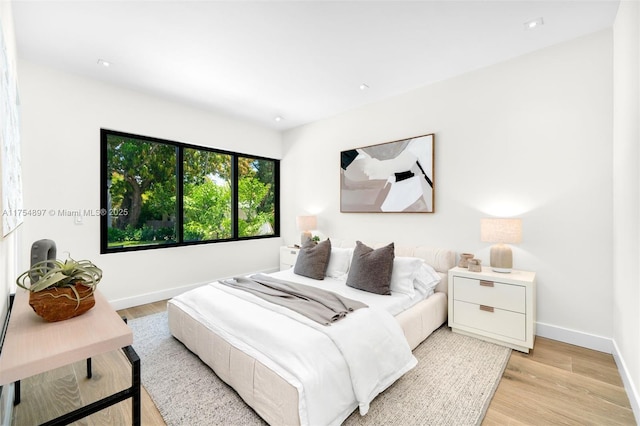 bedroom with light wood-style flooring and baseboards