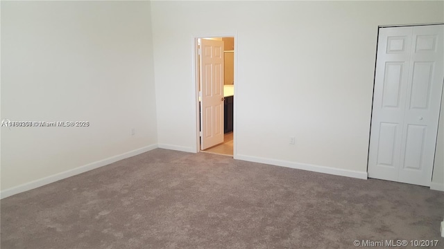 carpeted empty room with baseboards