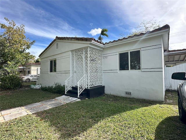 view of side of home featuring crawl space, a yard, and stucco siding