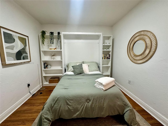 bedroom featuring dark wood-style floors and baseboards