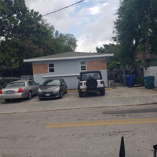 view of front of property with brick siding and fence