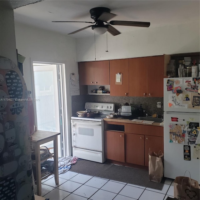 kitchen featuring brown cabinets, white appliances, a sink, and tasteful backsplash