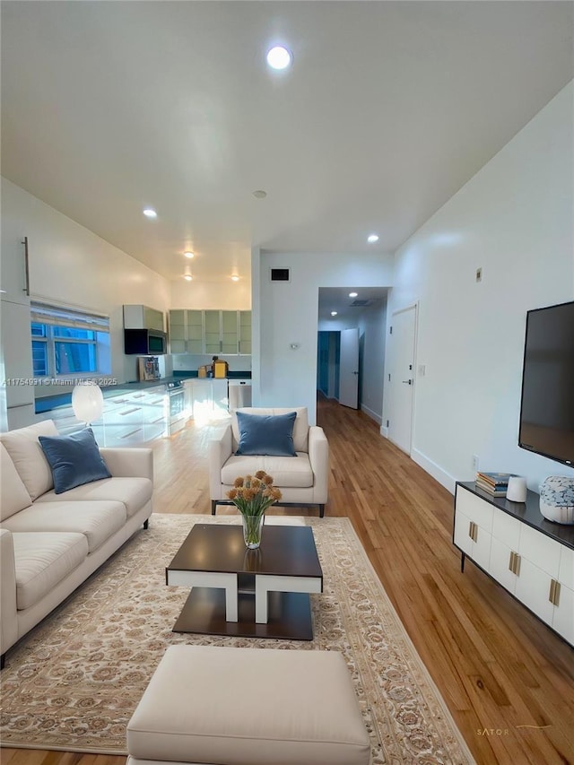 living room featuring wood finished floors, visible vents, and recessed lighting