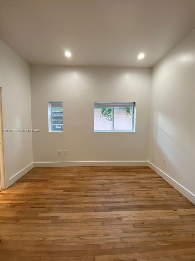 spare room with light wood-type flooring, baseboards, and recessed lighting