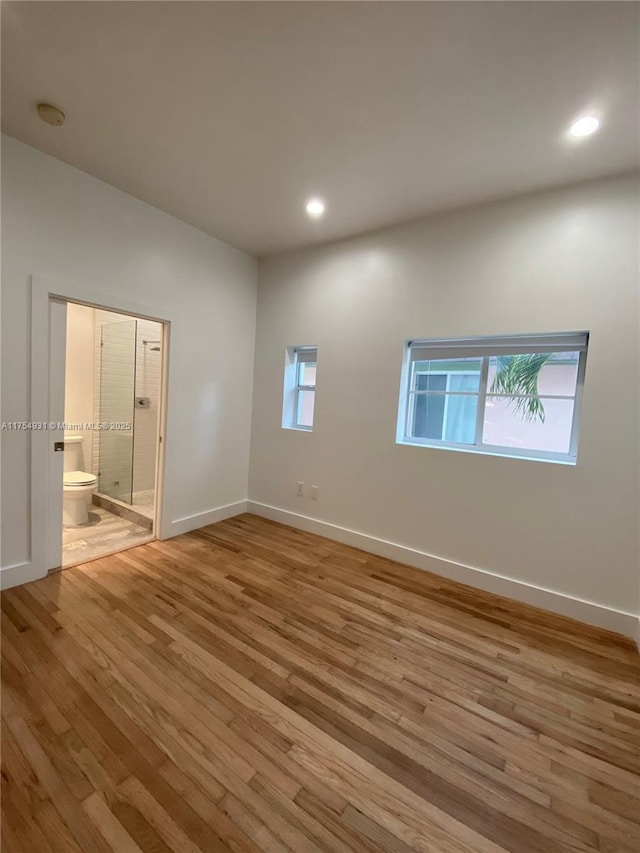 spare room with plenty of natural light, baseboards, wood finished floors, and recessed lighting