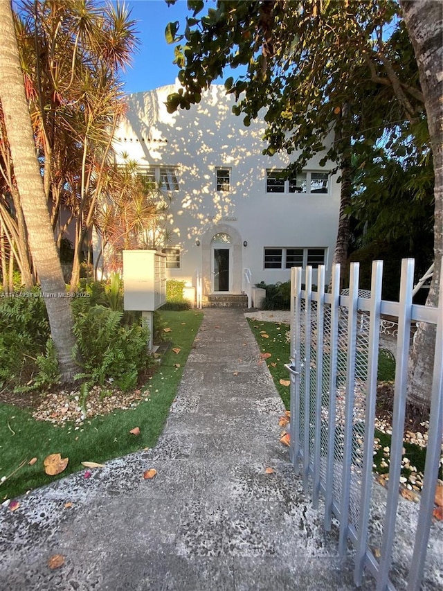 view of front facade with fence and stucco siding