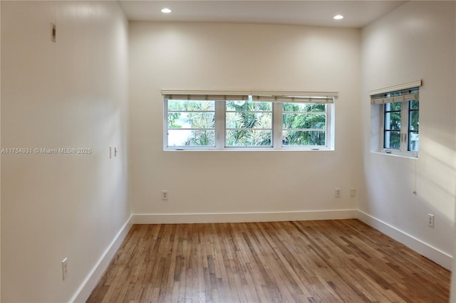 unfurnished room featuring plenty of natural light, baseboards, light wood-style flooring, and recessed lighting