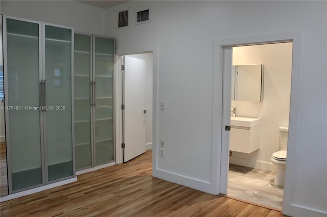 bathroom with toilet, visible vents, wood finished floors, and vanity