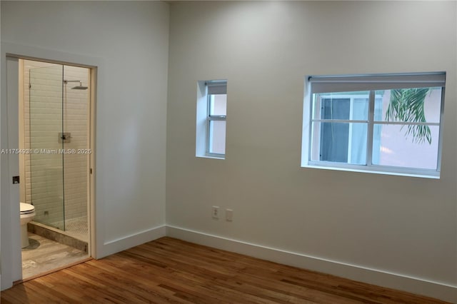 empty room with baseboards and wood finished floors