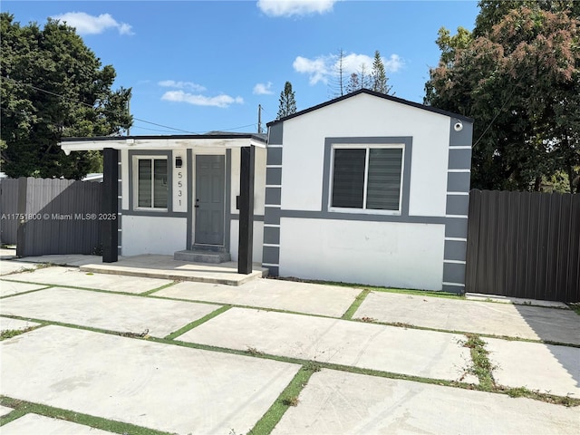 view of front of house featuring fence and stucco siding