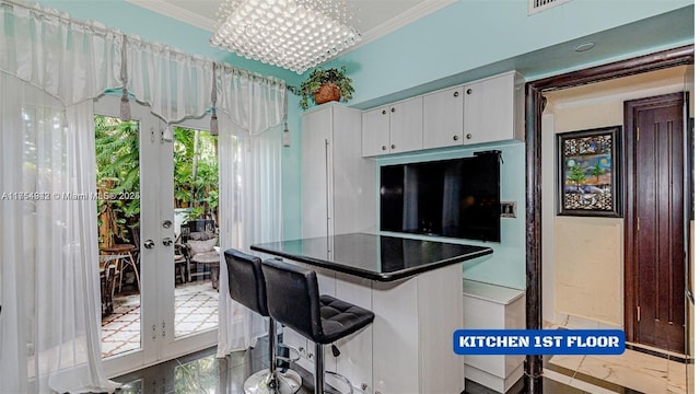 430 Poinciana Dr Unit 1710, Sunny Isles Beach, FL 33160 - kitchen featuring french doors, ornamental molding, dark countertops, and white cabinets