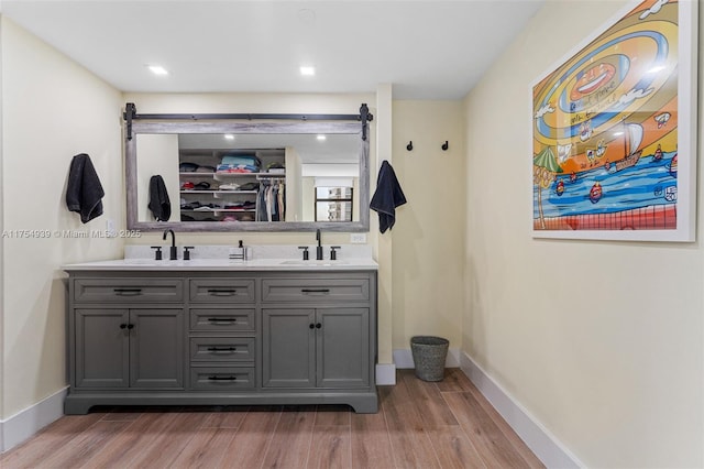 bar with a barn door, baseboards, and wood finished floors