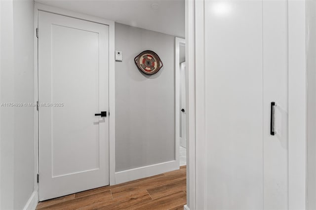 hall with wood finished floors and baseboards