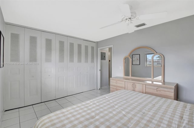 unfurnished bedroom with light tile patterned floors, a ceiling fan, visible vents, and a closet