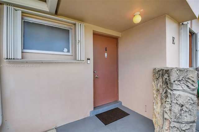 doorway to property featuring stucco siding