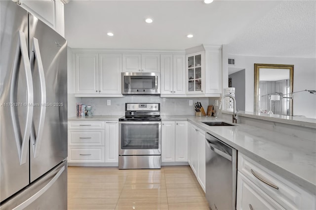 10777 W Sample Rd Unit 912, Coral Springs, FL 33065 - kitchen with appliances with stainless steel finishes, a sink, white cabinets, glass insert cabinets, and light stone counters