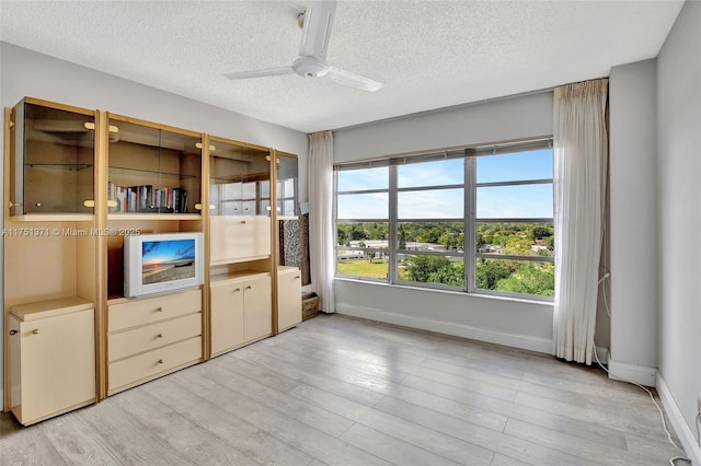 10777 W Sample Rd Unit 912, Coral Springs, FL 33065 - unfurnished bedroom featuring a textured ceiling, baseboards, light wood finished floors, and a ceiling fan