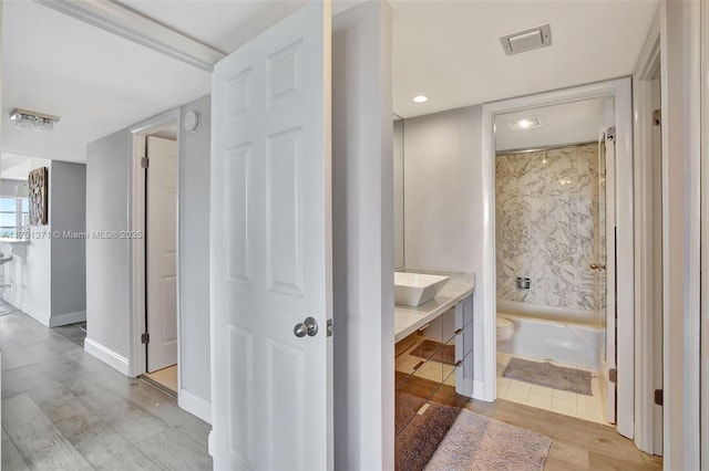 full bathroom featuring baseboards, visible vents, toilet, wood finished floors, and vanity