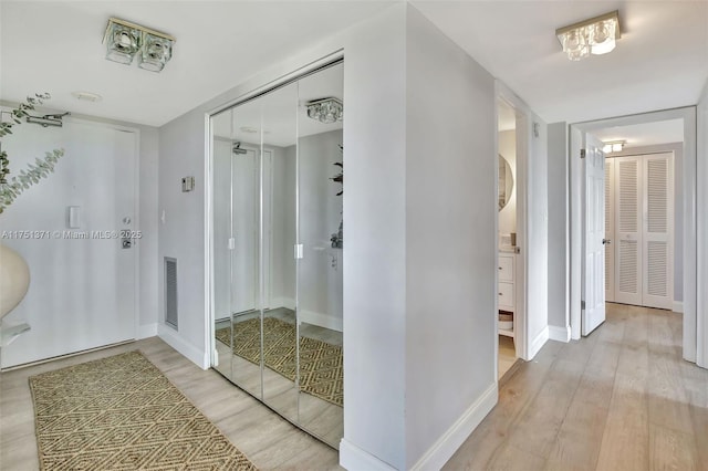 bathroom with baseboards, visible vents, and wood finished floors