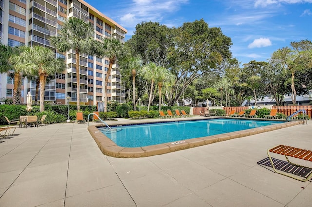 pool with a patio area and fence