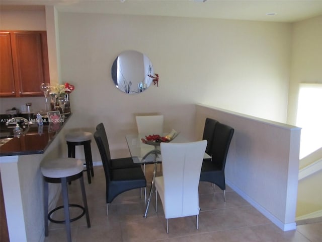 dining area featuring light tile patterned flooring and baseboards