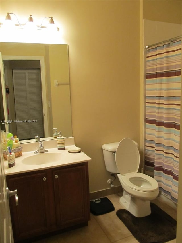 bathroom featuring baseboards, toilet, a shower with curtain, tile patterned floors, and vanity