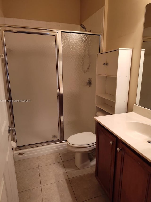 full bath with vanity, a stall shower, tile patterned flooring, and toilet