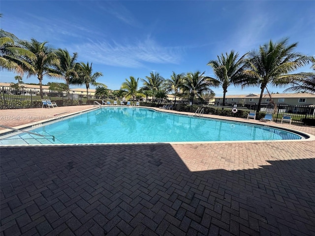 community pool featuring fence and a patio