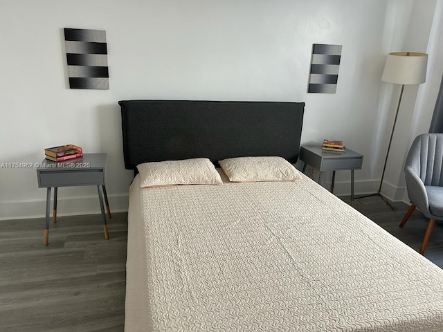 bedroom featuring dark wood-type flooring and baseboards